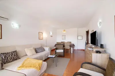 a living room with a couch and a tv at Tenis Golfmar in Vilamoura