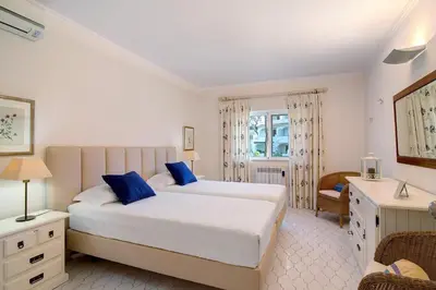a bedroom with two beds with blue pillows at Bia in Almancil