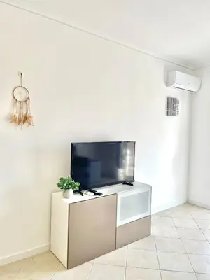 a living room with a flat screen tv on a white wall at Flat Luxuoso Praia da Oura in Albufeira