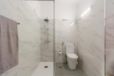 a bathroom with a toilet and a glass shower at Vila Amélia by Sunnyway in Albufeira