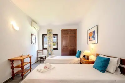 a bedroom with two beds and a desk and a window at Vila Amélia by Sunnyway in Albufeira