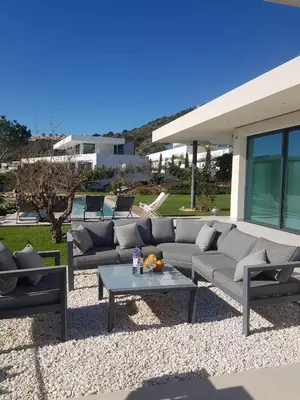 a patio with couches and a table and a house at Casa Papoila in Albufeira