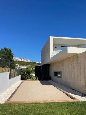 a modern house with a concrete wall at Casa Papoila in Albufeira