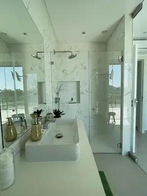 a white bathroom with a sink and a shower at Casa Papoila in Albufeira