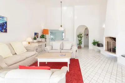 a white bedroom with a bed and a desk at Villa Rosa in Vale do Lobo
