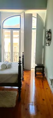 a bedroom with a bed and a large window at Grand Studio 54 in Faro