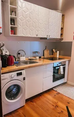a kitchen with a washing machine and a sink at Grand Studio 54 in Faro