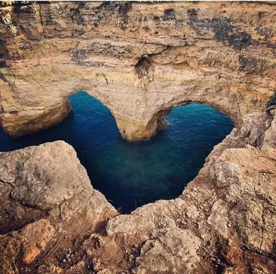an arch in the rocks near the water at Design Chalet in Albufeira With Private Pool in Albufeira