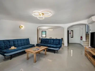 a living room with blue couches and a coffee table at Villa Corcovada V4 VIP Properties by Interhome in Albufeira