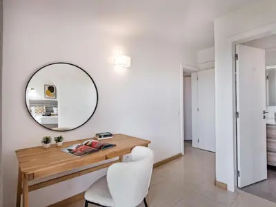 a white room with a wooden table and a mirror at Villa Jenny - VIP Properties by Interhome in Albufeira