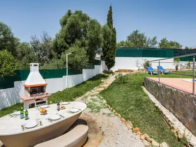 a group of chairs in the grass in front of a house at Villa Jenny - VIP Properties by Interhome in Albufeira