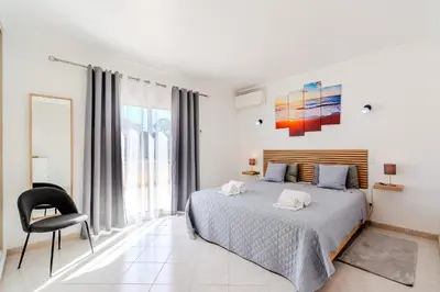 a basket of fruit and a bottle of wine on a table at Villa Orange with private pool Albufeira in Albufeira