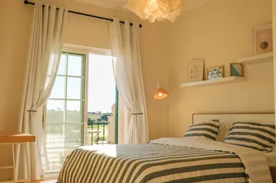 a bedroom with a bed and a large window at Quinta do Lago Golfside Retreat in Quinta do Lago
