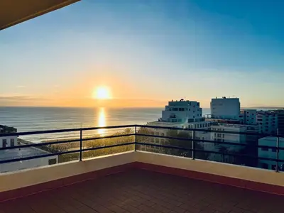 a balcony with a view of the ocean at sunset at Pérola do Algarve in Quarteira