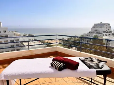 a bed on a balcony with a view of the ocean at Pérola do Algarve in Quarteira