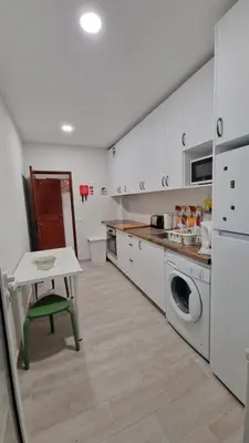 a kitchen with a table and a washing machine at AREIAS SOL in Albufeira