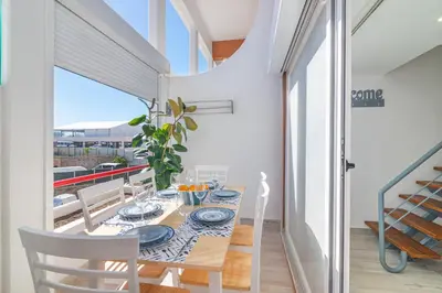 a dining room with a table and chairs and a balcony at Flat with Pool T2 Duplex Montechoro in Albufeira