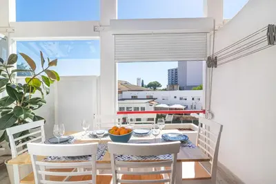 a dining room with a table and chairs and a window at Flat with Pool T2 Duplex Montechoro in Albufeira