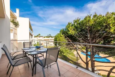 a patio with a table and chairs on a balcony at Balaia Residense Penthouse 2 Bedroom Apartment with Pool in Albufeira