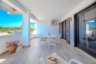 a living room with a table and chairs and a large window at Apartamento Ivone by Sunnyway in Albufeira