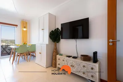 a living room with a tv on a wall at #152 T1 Falésia by Home Holidays in Albufeira