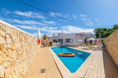 a pool with a frisbee next to a stone wall at Villa Mar do Estrela in Galé