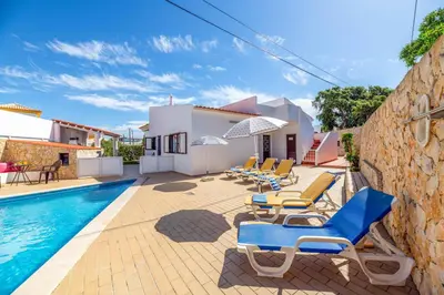 a villa with a swimming pool and lounge chairs at Villa Mar do Estrela in Galé