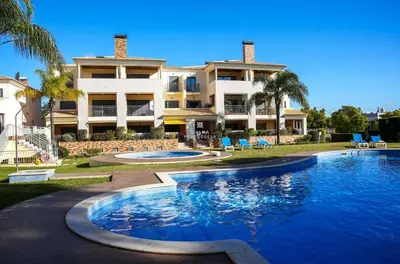 a resort with a swimming pool in front of a building at Apartment - Vilamoura Pine By Dalma Portuguesa in Quarteira