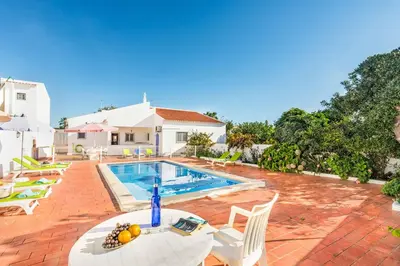 a swimming pool with a table and chairs next to a house at Villa Bento Dios in Galé