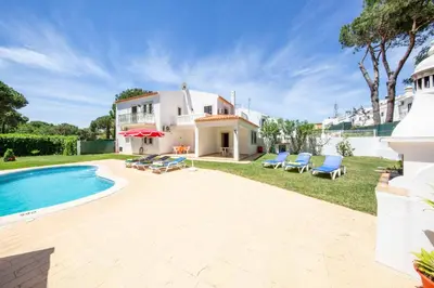 a villa with a swimming pool and a house at Villa Mendes in Vilamoura