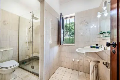 a bathroom with a toilet and a sink and a shower at Villa Mendes in Vilamoura