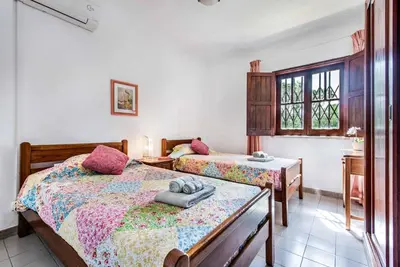 a bedroom with two beds and a window at Villa Mendes in Vilamoura