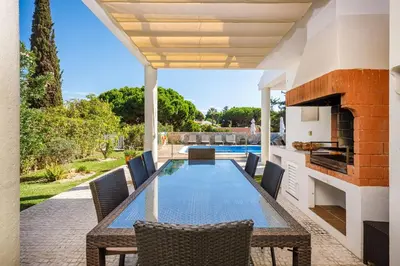 a patio with a table and chairs and a fireplace at Charming Vale Do Lobo Villa 4 Bedrooms Villa Quadradinhos 22 Private Pool in Almancil