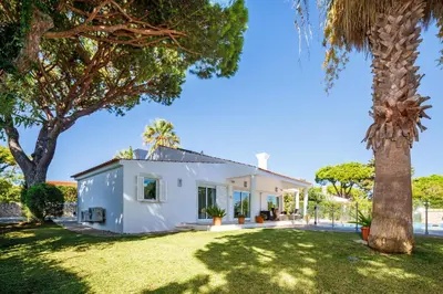 a white house with a palm tree at Charming Vale Do Lobo Villa 4 Bedrooms Villa Quadradinhos 22 Private Pool in Almancil