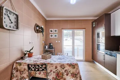 a kitchen with a table and a clock on the wall at NEU - Casa Tina mit Meerblick und Pool in Guia