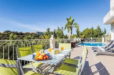 a table with a bowl of fruit on top of a balcony at Villa Encosta do Sol in Albufeira