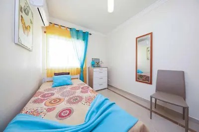 a bedroom with a bed and a chair in it at Villa Encosta do Sol in Albufeira