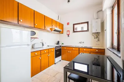 a kitchen with wooden cabinets and a black table at Mar&Mar Old Town 2 Bedroom Apartment in Albufeira