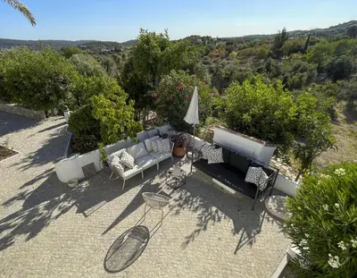 an outdoor patio with couches and an umbrella at Casa Estrela in Loulé