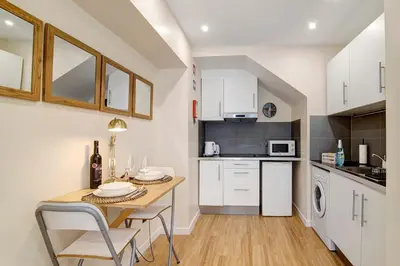 a kitchen with white cabinets and a washer and dryer at Bougainvillea House in Faro