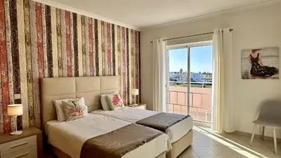 a bedroom with a bed and a large window at Antonieta by Check-in Portugal in Albufeira