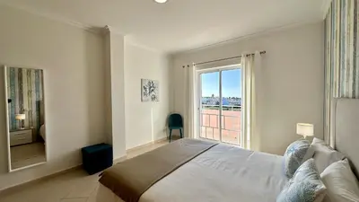 a bedroom with a large bed and a large window at Antonieta by Check-in Portugal in Albufeira