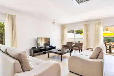 a living room with two white couches and a television at Villa Cabrita de Parra in Galé