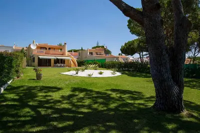 a yard with a tree and a house at Villa Daffodil Golf in Vilamoura
