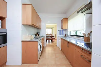 a kitchen with wooden cabinets and a dishwasher at Villa Daffodil Golf in Vilamoura