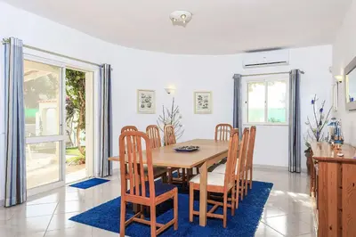 a dining room with a wooden table and chairs at Villa Mica in Azinhal