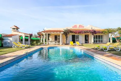 a swimming pool in front of a house at Villa Mica in Azinhal