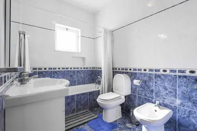 a blue and white bathroom with a toilet and a sink at Villa Mica in Azinhal