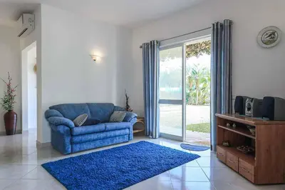 a living room with a blue couch and a sliding glass door at Villa Mica in Azinhal