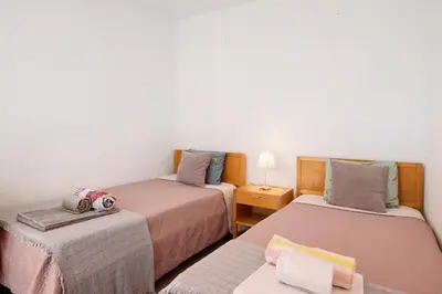 a room with two beds and a table at Villa Lynn - Quadradinhos in Almancil